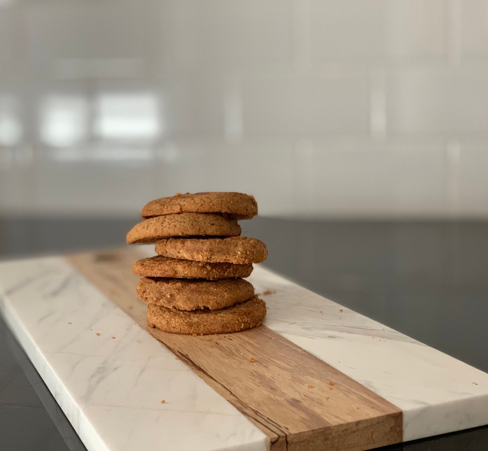 A stack of cookies sitting on top of a wooden cutting board.