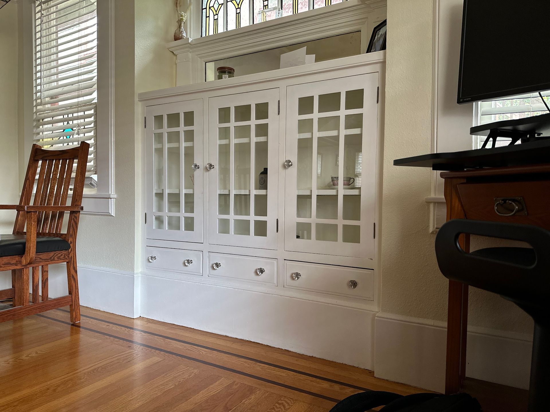 A living room with a chair , desk , and computer.