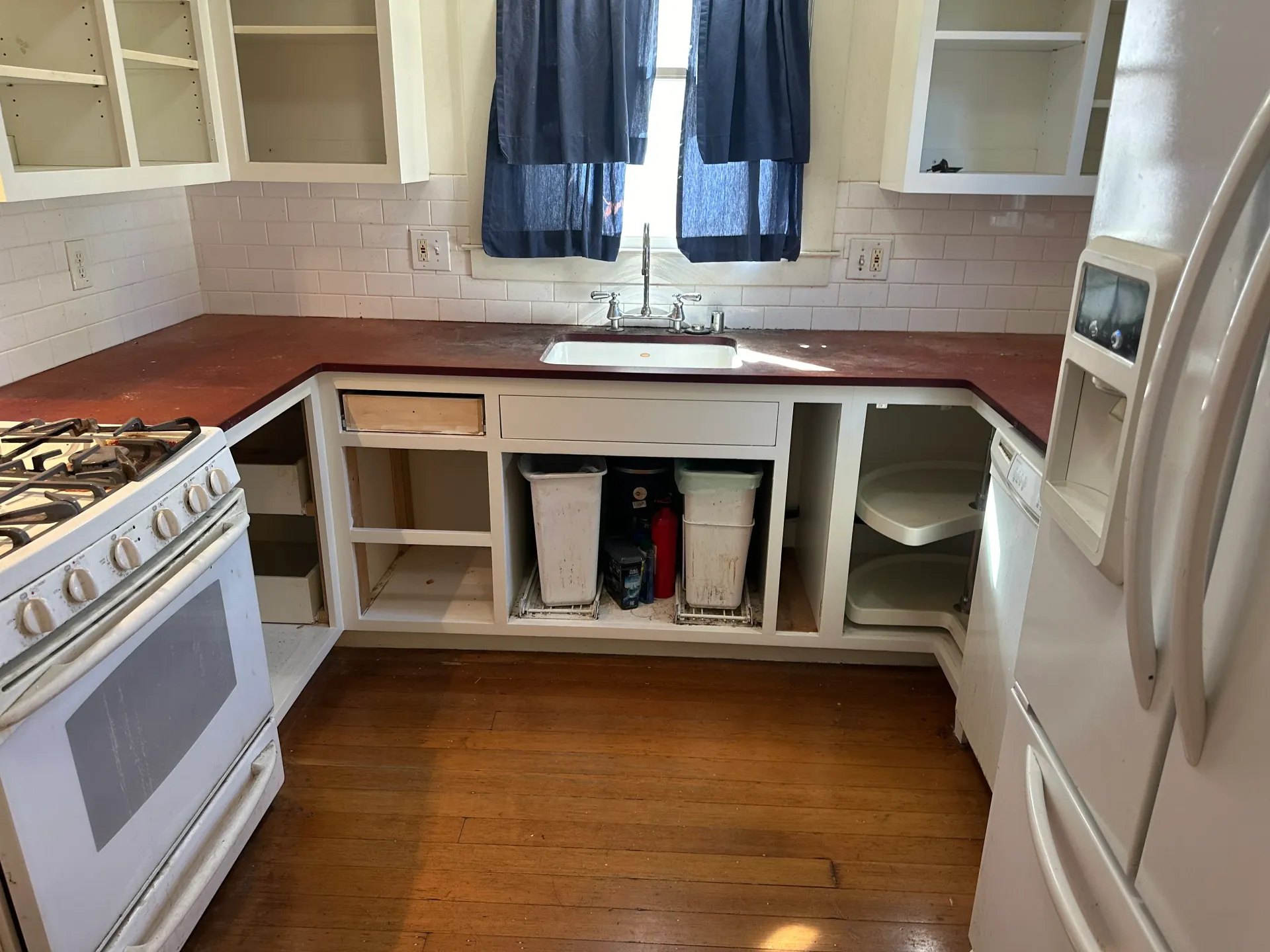 A kitchen with a stove a refrigerator and a sink