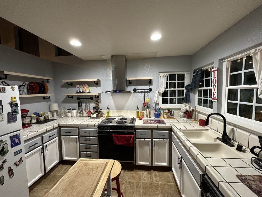 A kitchen with a stove , sink , and refrigerator.