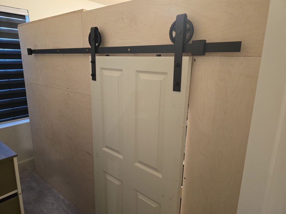 A sliding barn door is hanging on a wall in a room.