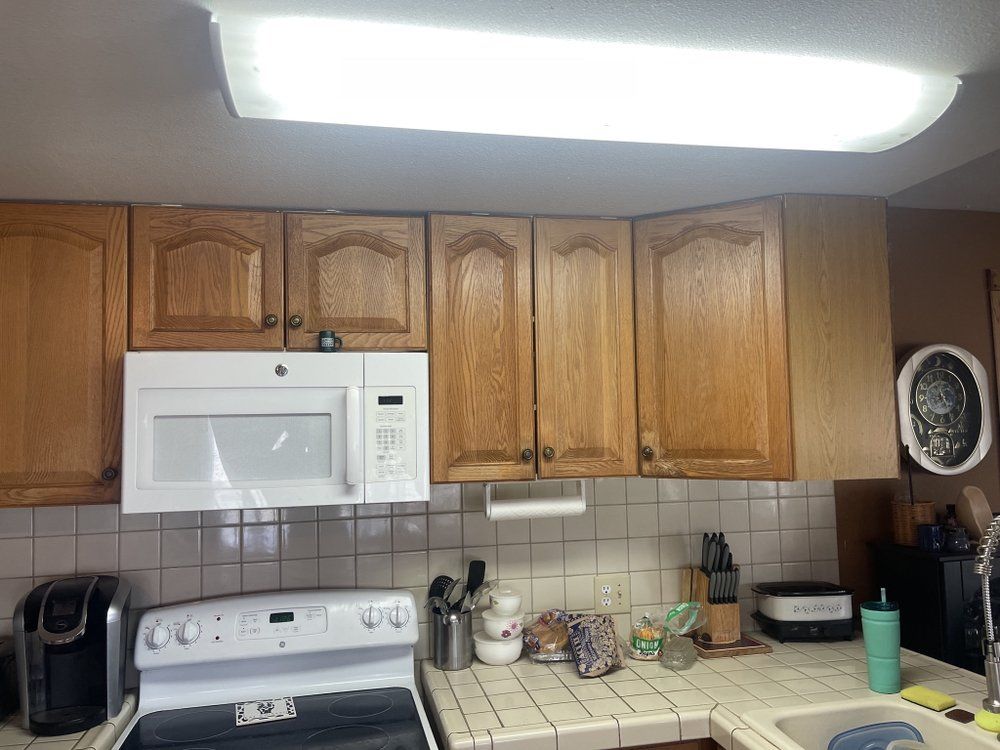 A kitchen with wooden cabinets and a white stove top oven
