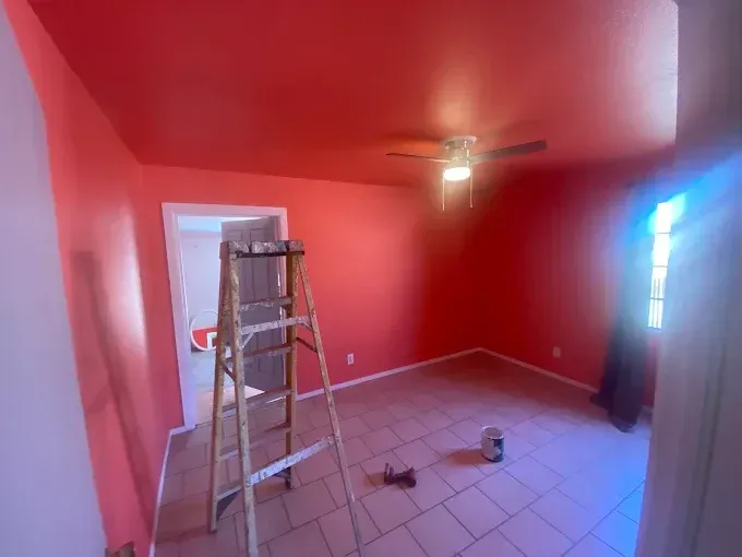Room painted red with a ladder inside. A doorway and window are visible.