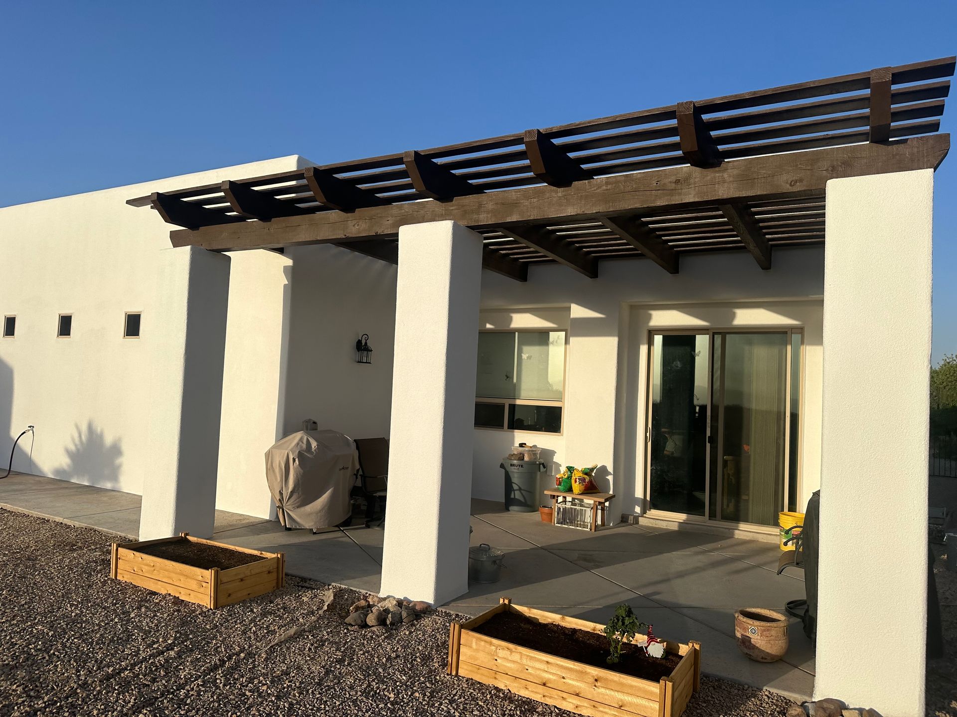 Yellow house with white trim, arched entry, lush green lawn, and vibrant landscaping.