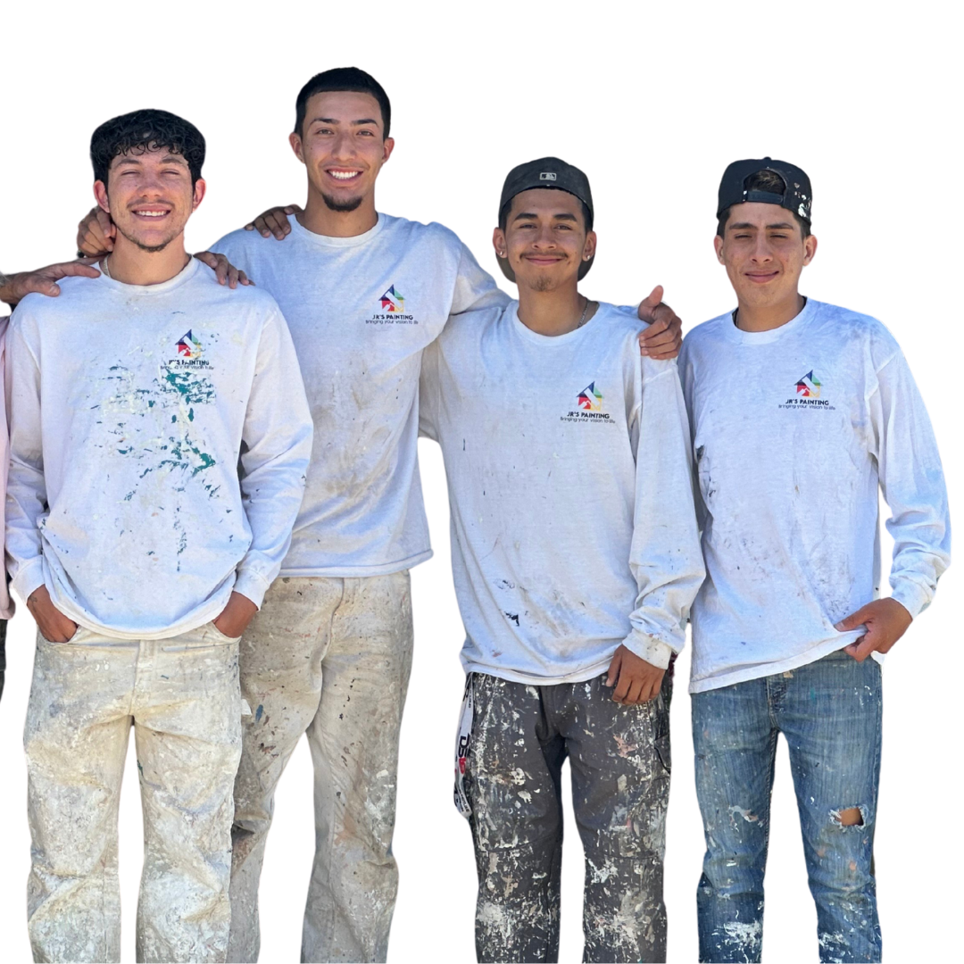 Smiling painter in white overalls, thumbs up, holding paint roller.