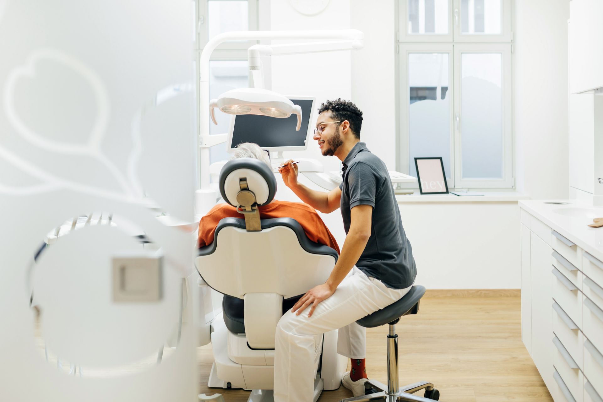 A woman is getting her teeth removed by a dentist in a dental office.