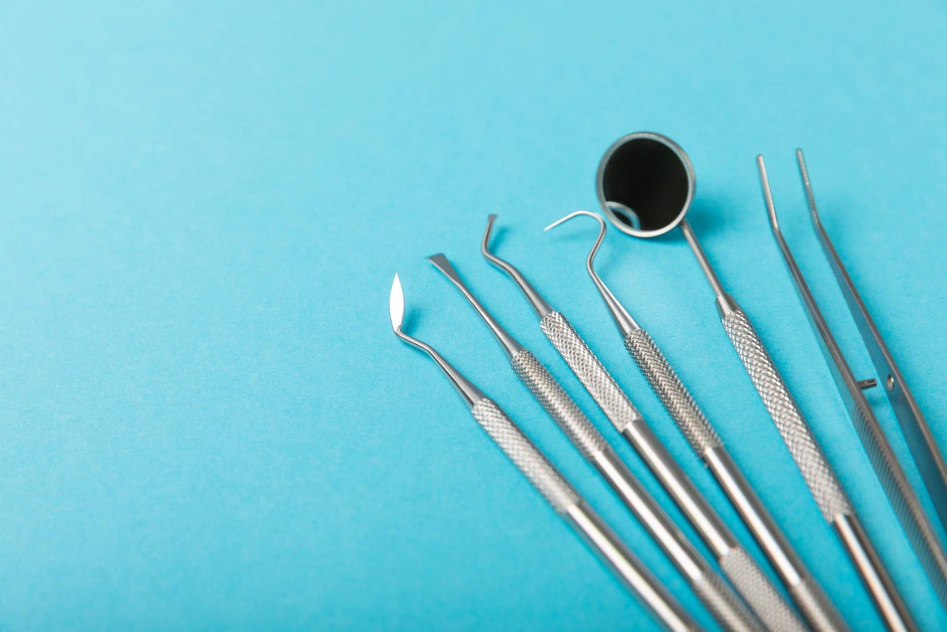 Dentist tools on a blue background, used for oral surgery.