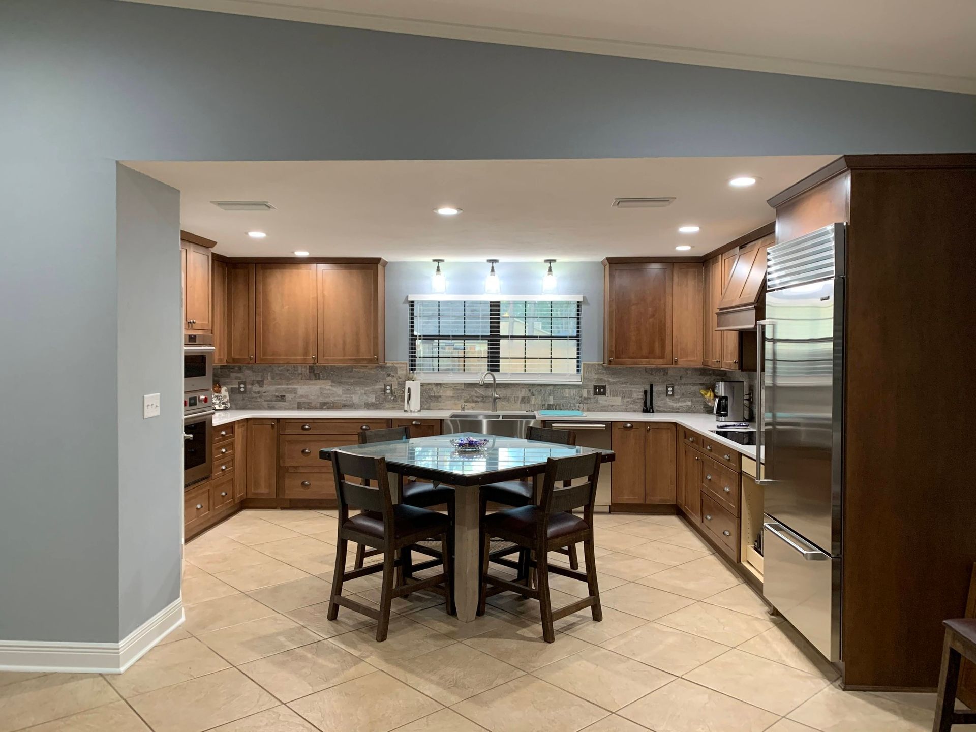 A kitchen with a table and chairs in it.