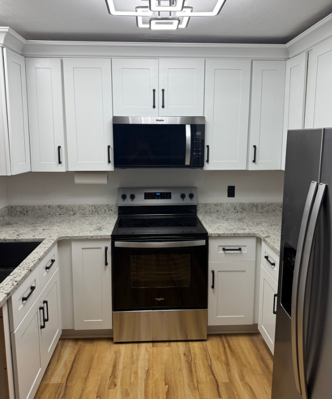 A kitchen with stainless steel appliances and white cabinets