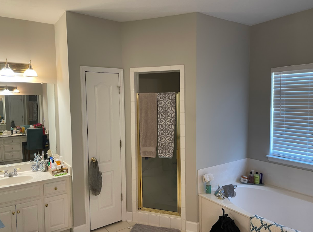 A bathroom with a bathtub , shower and mirror.