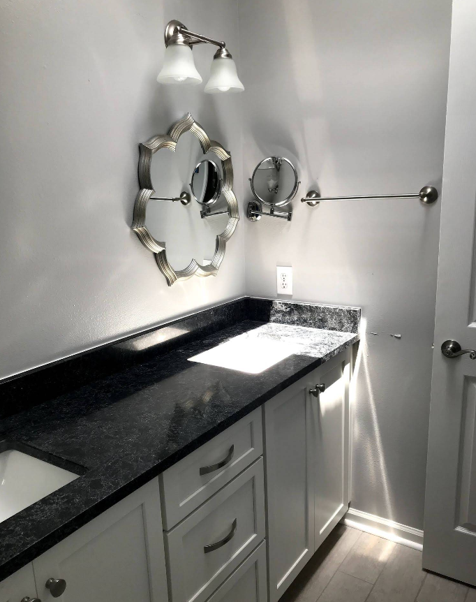 A bathroom with a sink and two mirrors on the wall