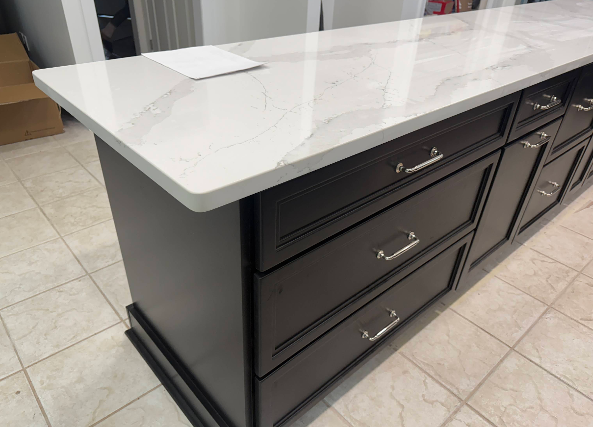 A kitchen with wooden cabinets and white counter tops