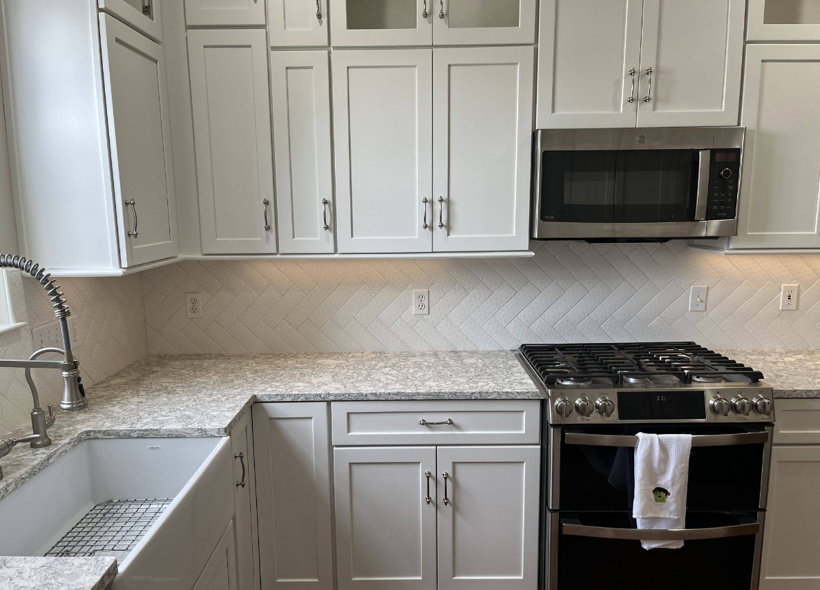 A kitchen with white cabinets and granite counter tops