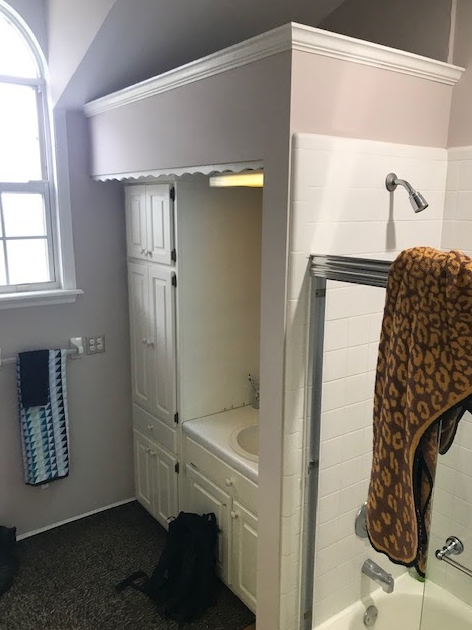 A bathroom with a bathtub , shower and mirror.