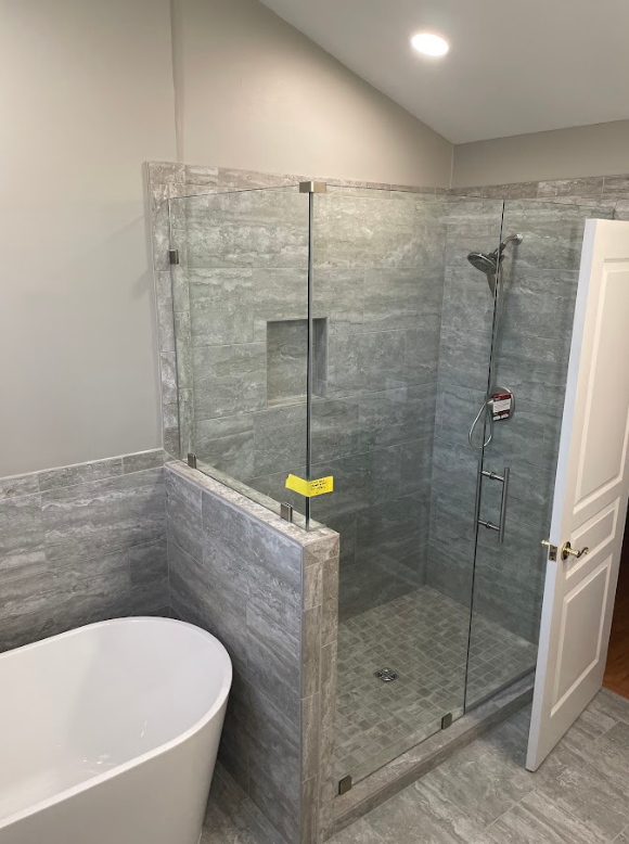 A bathroom with a walk in shower and a bathtub.