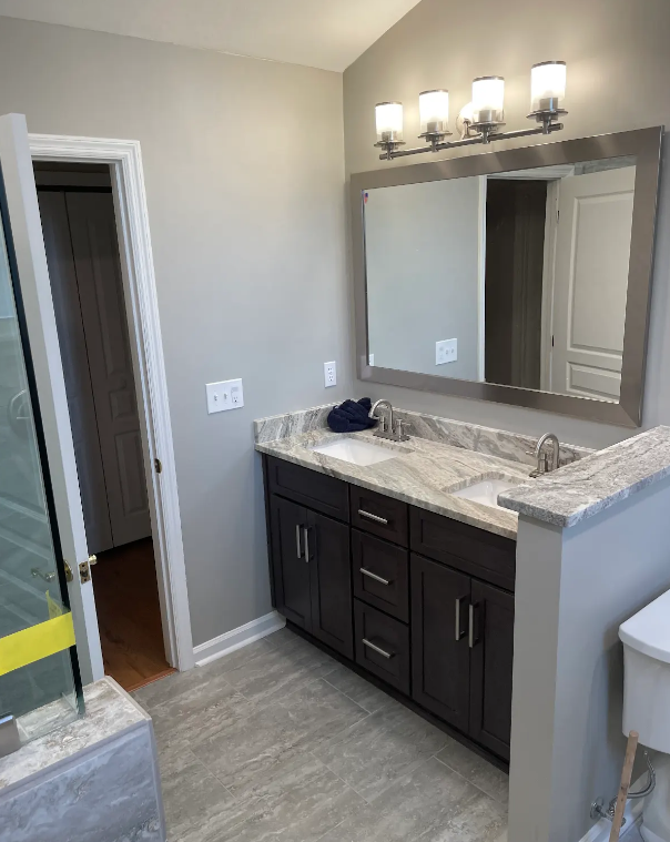 A bathroom with a sink , mirror and cabinets.