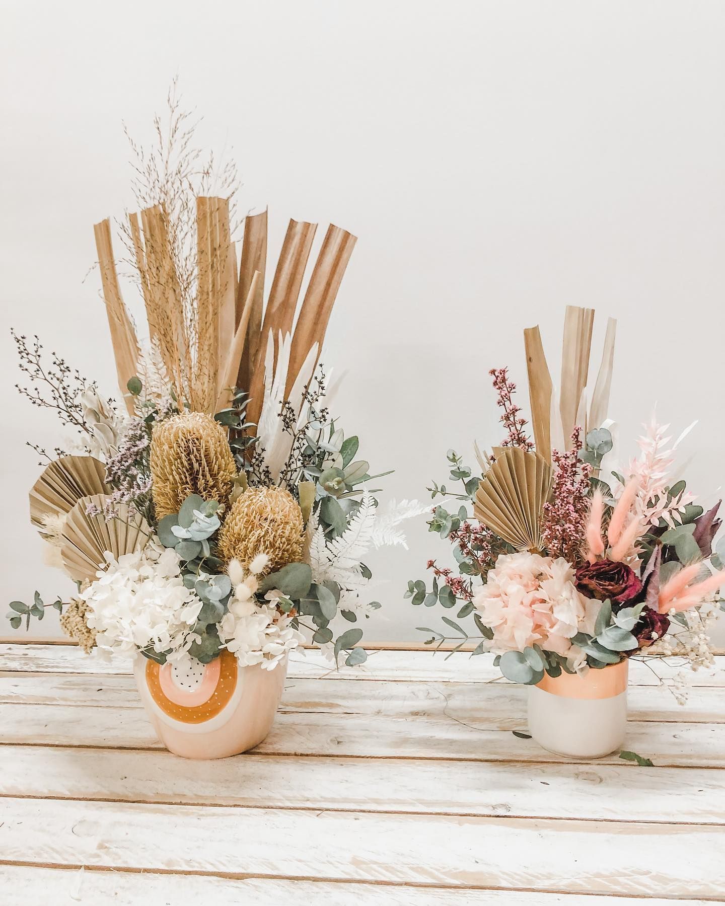 Two Vases Filled With Flowers Are Sitting on a Wooden Table — Suncoast Flowers in Birtinya, QLD