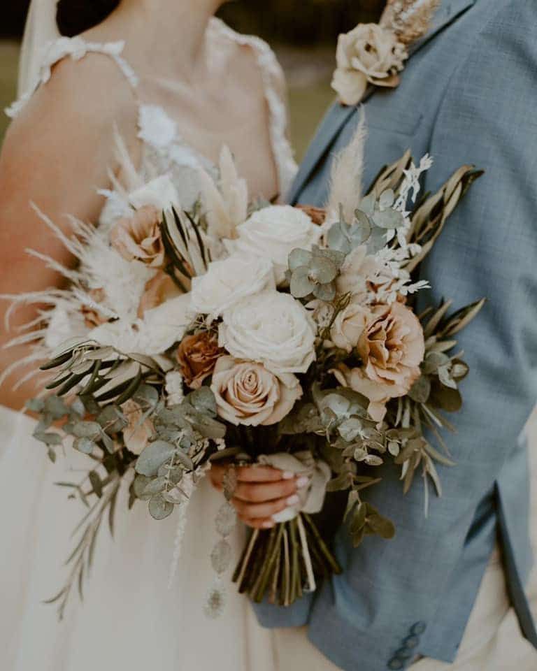 A Bride and Groom Are Holding a Bouquet of Flowers — Suncoast Flowers in Birtinya, QLD