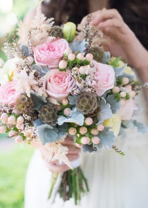 A Woman in a White Dress is Holding a Bouquet of Pink and Blue Flowers — Suncoast Flowers in Birtinya, QLD