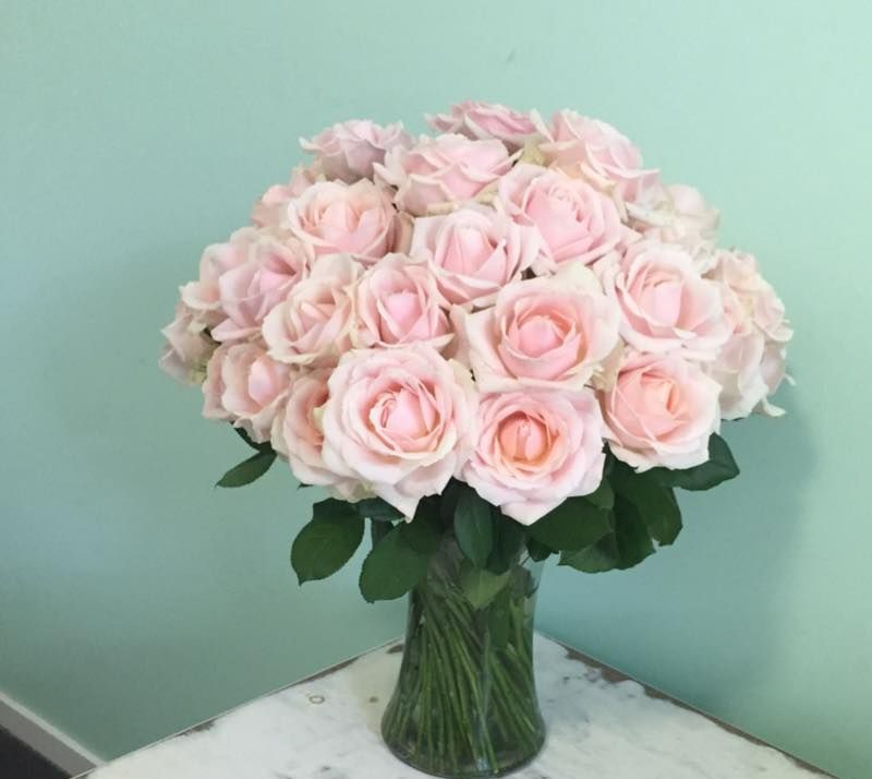 A Vase Filled With Pink Roses is Sitting on a Table — Suncoast Flowers in Birtinya, QLD