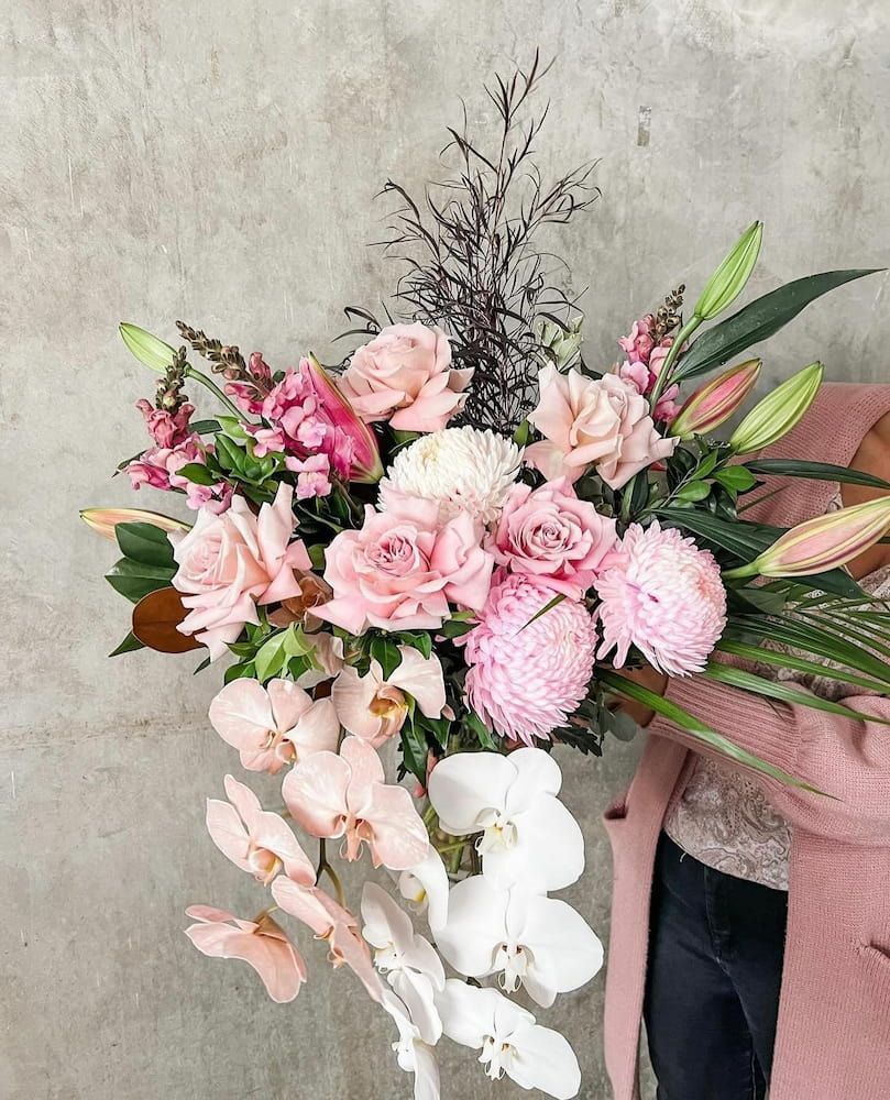 A Woman is Holding a Large Bouquet of Pink and White Flowers — Suncoast Flowers in Birtinya, QLD