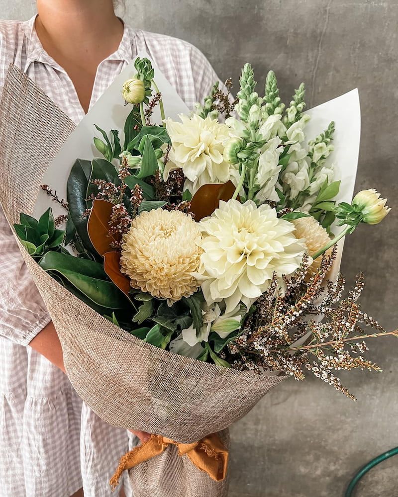 A Woman is Holding a Bouquet of White Flowers Wrapped in Burlap — Suncoast Flowers in Buderim, QLD
