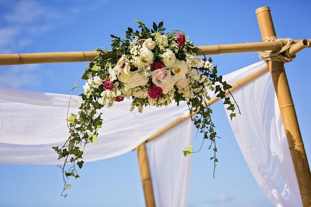 A Bamboo Arch Decorated With Flowers and White Cloth — Suncoast Flowers in Birtinya, QLD