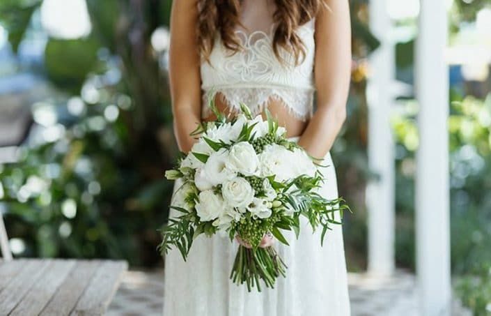 A Bride in a White Dress is Holding a Bouquet of White Flowers — Suncoast Flowers in Birtinya, QLD