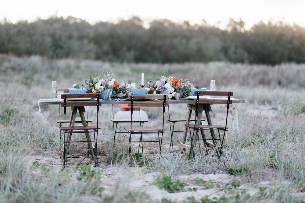A Table and Chairs in a Field With Flowers on It — Suncoast Flowers in Birtinya, QLD