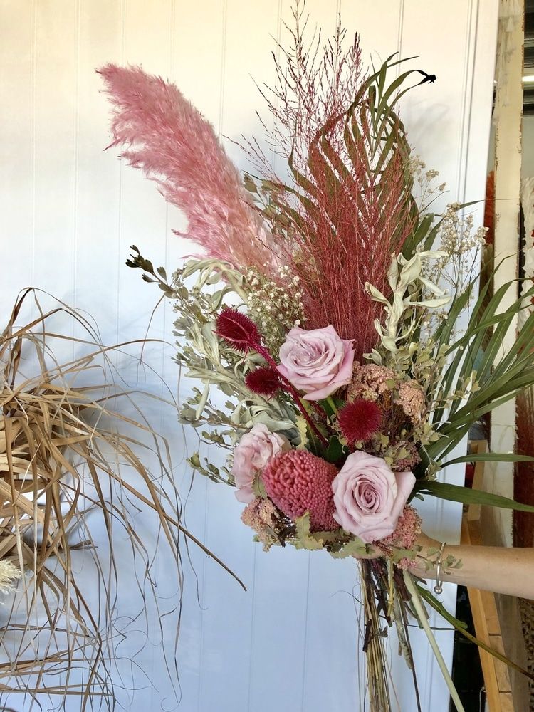 A Bouquet of Flowers is Sitting on a Table in Front of a White Wall — Suncoast Flowers in Birtinya, QLD