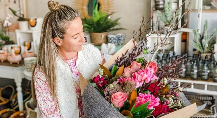 A Woman is Holding a Large Bouquet of Flowers in a Flower Shop — Suncoast Flowers in Birtinya, QLD