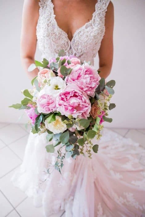 A Bride in a Wedding Dress is Holding a Bouquet of Pink and White Flowers — Suncoast Flowers in Birtinya, QLD