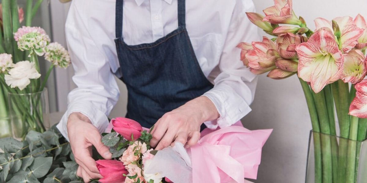 A Man in an Apron is Arranging Flowers in a Vase — Suncoast Flowers in Birtinya, QLD