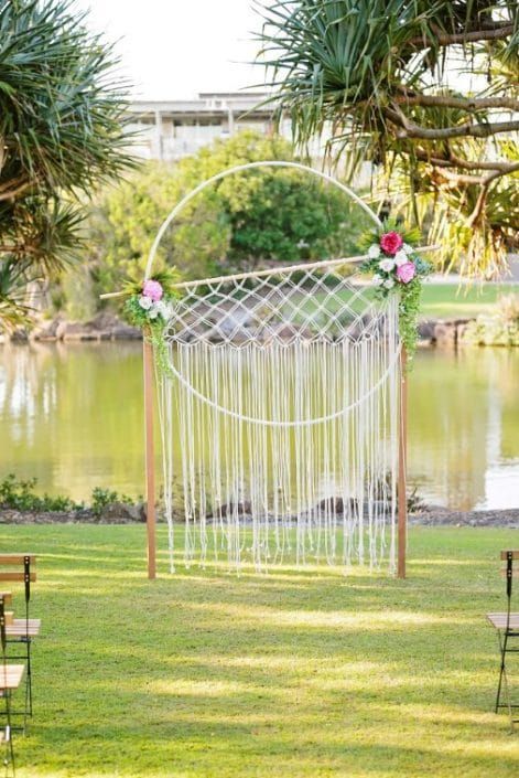 A Wedding Arch is Sitting on Top of a Lush Green Field Next to a Lake — Suncoast Flowers in Birtinya, QLD