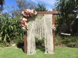 A Wooden Arch With Flowers on It is Sitting on Top of a Lush Green Field — Suncoast Flowers in Birtinya, QLD