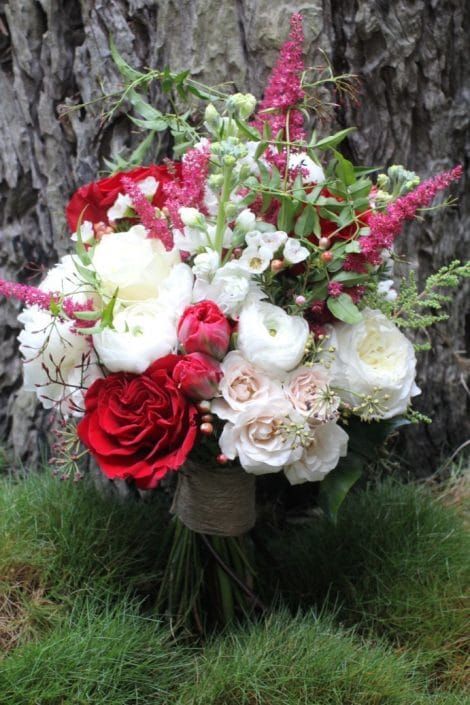 A Bouquet of Red and White Flowers is Sitting on Top of a Grass Covered Field — Suncoast Flowers in Birtinya, QLD