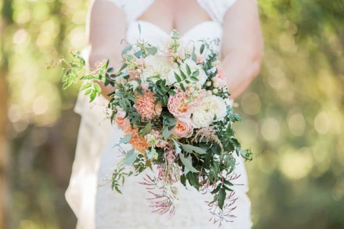 A Bride in a White Dress is Holding a Bouquet of Flowers — Suncoast Flowers in Birtinya, QLD