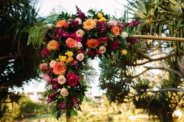 A Wooden Arch Decorated With Colorful Flowers is Surrounded by Trees — Suncoast Flowers in Birtinya, QLD