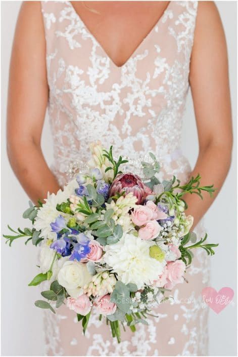 A Woman in a White Dress is Holding a Bouquet of Flowers — Suncoast Flowers in Birtinya, QLD