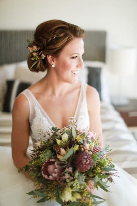 A Bride is Sitting on a Bed Holding a Bouquet of Flowers — Suncoast Flowers in Birtinya, QLD