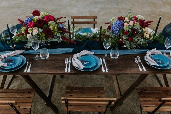 A Long Wooden Table With Plates, Silverware, and Flowers on It — Suncoast Flowers in Birtinya, QLD