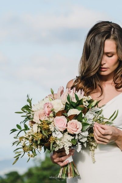 A Woman in a White Dress is Holding a Bouquet of Flowers — Suncoast Flowers in Birtinya, QLD