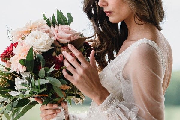 A Woman in a Wedding Dress is Holding a Bouquet of Flowers — Suncoast Flowers in Birtinya, QLD