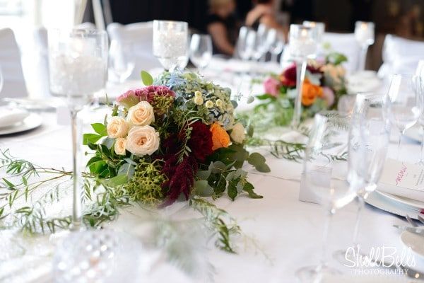 A Long Table With Flowers and Wine Glasses on It — Suncoast Flowers in Birtinya, QLD