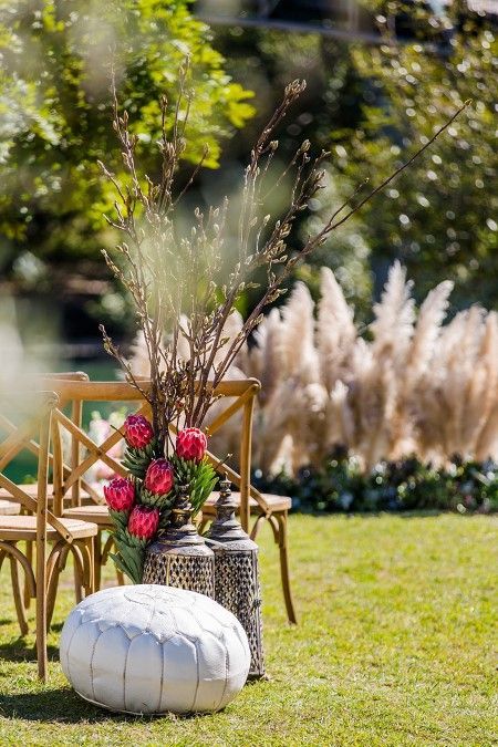 A White Ottoman is Sitting in the Grass Next to a Vase of Flowers — Suncoast Flowers in Birtinya, QLD
