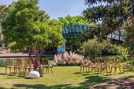 A Row of Chairs in a Grassy Field With a Bridge in the Background — Suncoast Flowers in Birtinya, QLD