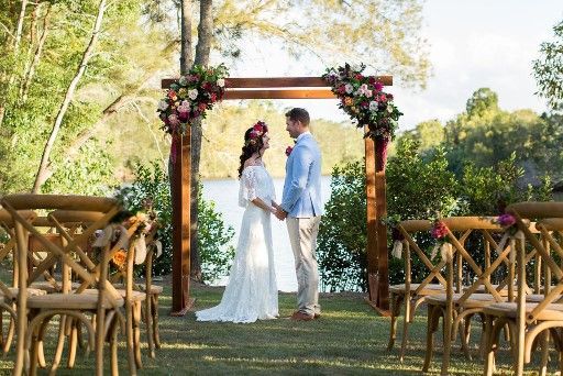 A Bride and Groom Are Holding Hands During Their Wedding Ceremony — Suncoast Flowers in Birtinya, QLD