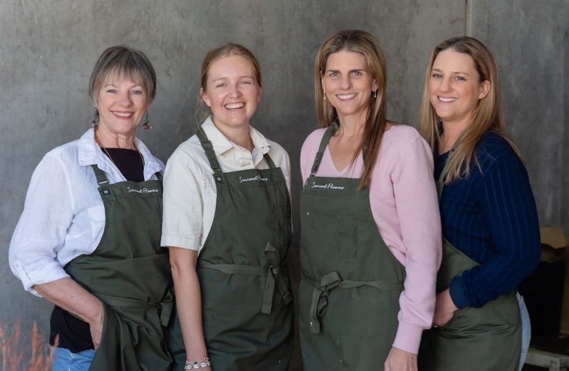 Four Women Wearing Aprons Are Posing for a Picture — Suncoast Flowers in Birtinya, QLD