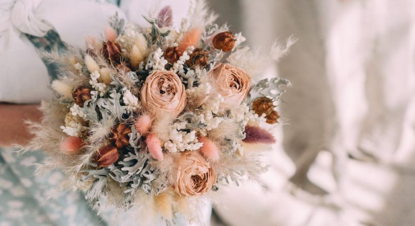 A Woman is Holding a Bouquet of Dried Flowers in Her Hands — Suncoast Flowers in Birtinya, QLD