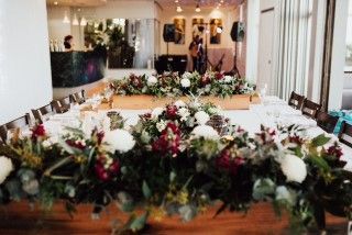 A Long Wooden Table With Flowers on It in a Room — Suncoast Flowers in Birtinya, QLD